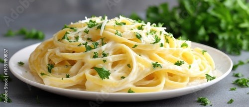 Creamy fettuccine Alfredo garnished with fresh parsley and grated cheese on a white plate.