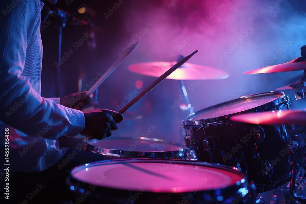 Obraz premium Drummer plays under vibrant stage lights.