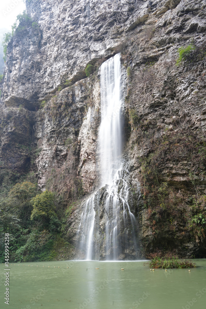 Obraz premium Majestic Waterfall Cascading Down a Rugged Cliff Face