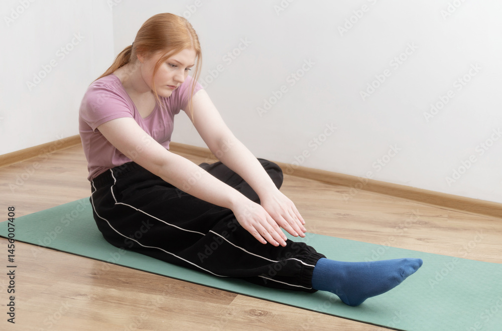 young woman doing physical exercises on the floor at home