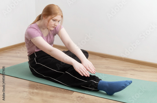 Obraz na płótnie young woman doing physical exercises on the floor at home w salonie