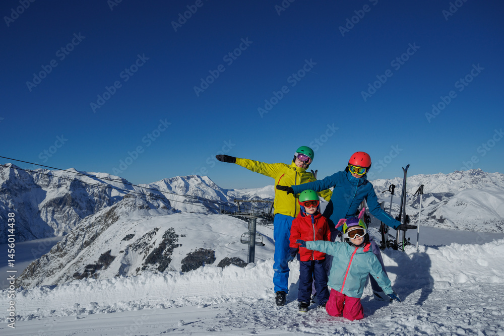 Mom and dad holding kids on ski run, ready for the first slide