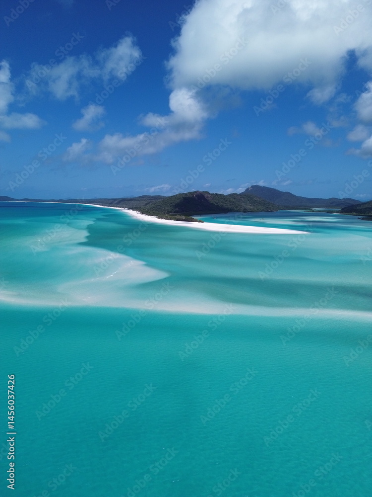 Fototapeta premium 4K drone footage of a breathtaking sunset over the Whitsunday Islands, Australia. Crystal clear waters, pristine beaches, and stunning tropical scenery – a true island paradise.
