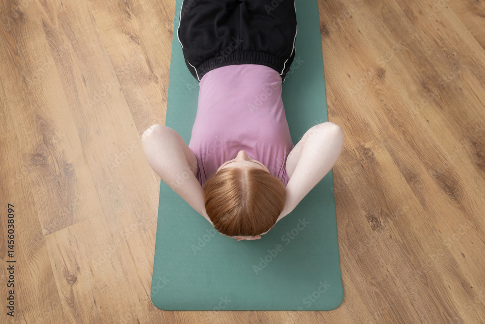 young woman doing physical exercises on the floor at home