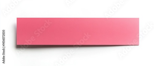 Pink rectangular sticker sits against white backdrop casting distinct shadow offering minimalist presentation.