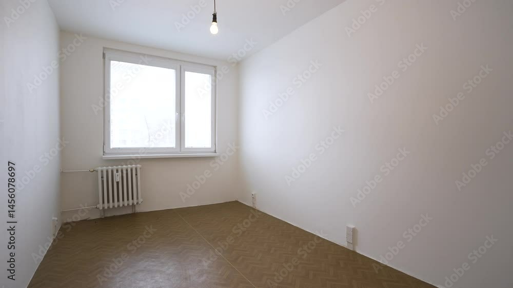 An empty room with a window and heating in an apartment for rent An empty room with a window and heating in an apartment for rent