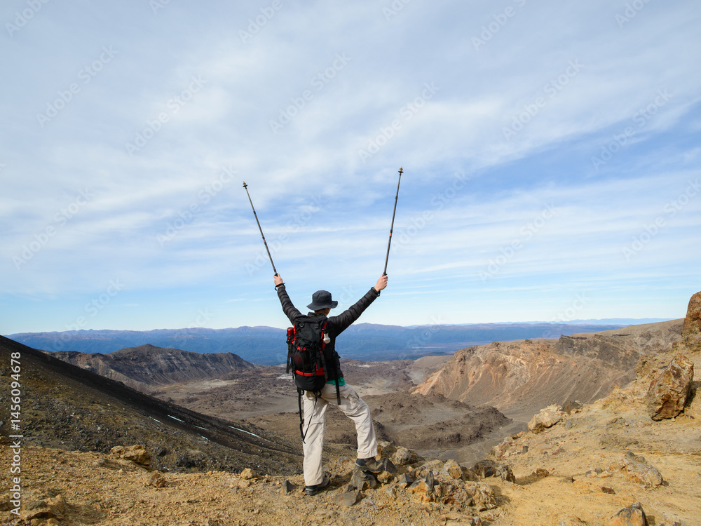 Man with arms raised at Tongariro Alpine crossing, Tongariro National Park. New Zealand.
