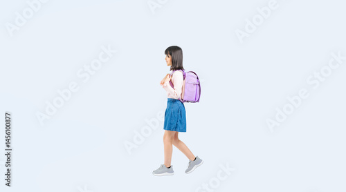 横向きに歩くランドセルを背負った小学生の女の子の全身写真（切り抜き背景透過PNGも販売しております。↓作成者リンクから「PNG」で検索してください）