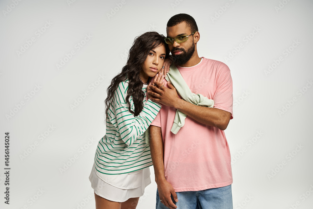Naklejka premium Stylish couple embraces love and fashion in a modern studio setting