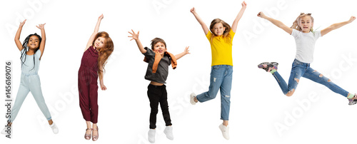 Five elementary school kids or pupils jumping in colorful casual clothes isolated on transparent background. Creative collage. Back to school, education, childhood concept. Cheerful girls and boy.