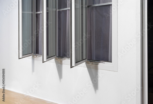 Obraz na płótnie Three panel aluminium casement window stay on white wall.