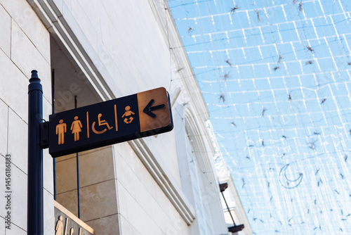 Directional sign indicating restrooms and accessibility features in public space