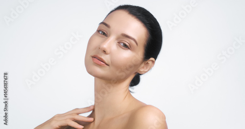 Obraz na płótnie High-quality studio portrait of a graceful young woman with glowing skin and bare shoulders. Ideal for wellness, skincare advertising, beauty banners, and elegant promotional content. w salonie