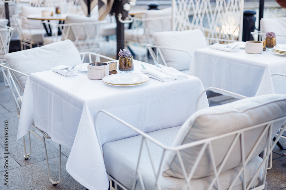 Fototapeta premium Elegant outdoor seating near a fountain in a vibrant urban plaza during evening hours