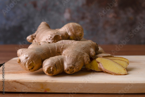 Cup of tea with ginger root on a wooden table, Ginger tea with and honey on a gray background.