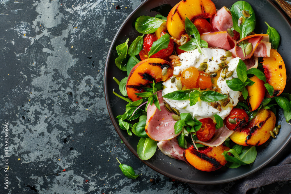 A gourmet breakfast plate with sunny side up eggs, prosciutto, peaches, and fresh greens on a dark slate background.