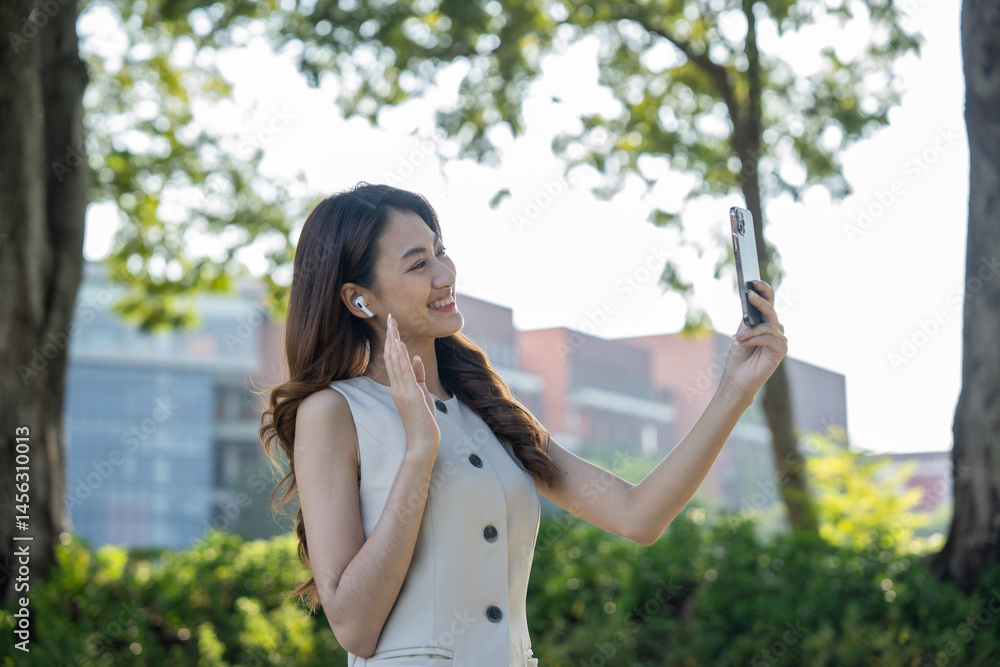 Young asian business woman with headset talking on smartphone standing in the garden public park. Cheerful woman discussion conference on smartphone Young asian business woman with headset talking on smartphone standing in the garden public park. Cheerful woman discussion conference on smartphone