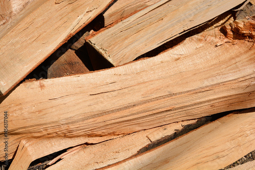 Obraz na płótnie A close-up shows a jumbled stack of light brown firewood pieces with visible wood grain w salonie