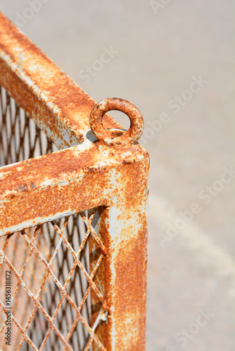 Obraz na płótnie A close-up shows a heavily rusted metal structure with a lifting ring at the corner, exhibiting significant corrosion w salonie