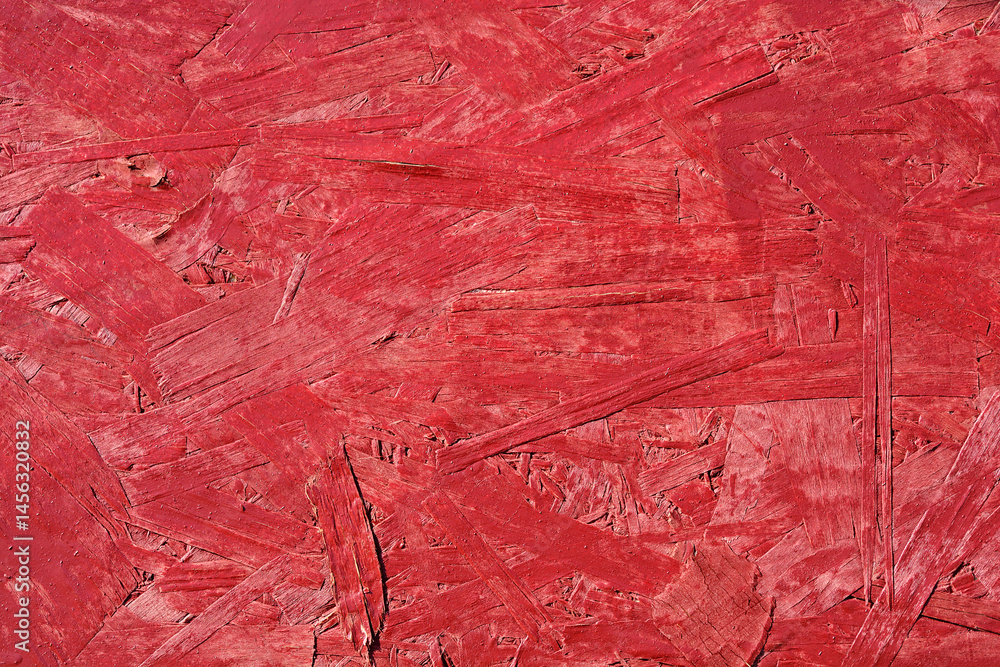 A close-up shows a textured red painted oriented strand board surface
