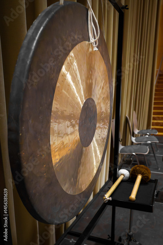 Obraz na plátně Large bronze gong with mallets on a stand in a concert venue, highlighting traditional percussion for music, culture, or performance concepts