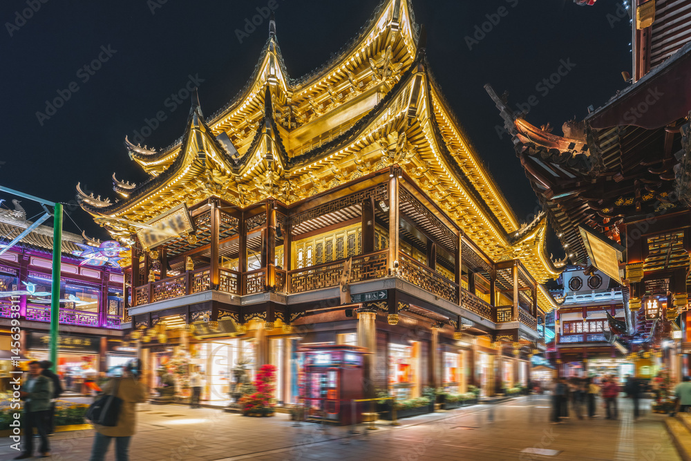 Naklejka premium Enchanting Night Market: Vibrant Lights and Traditional Architecture in Urban Setting