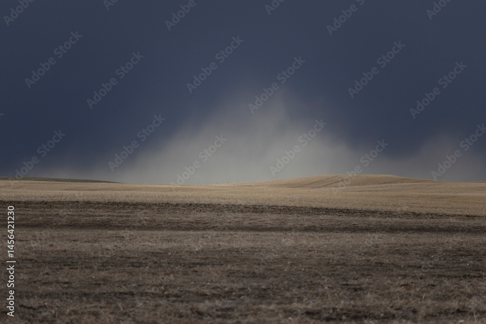 Dramatic storm clouds in a moody sky above an agricultural field. Dramatic storm clouds in a moody sky above an agricultural field.