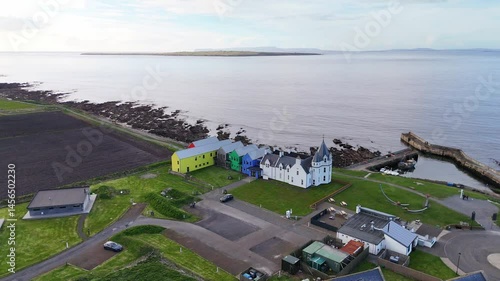 Drone shot of colourful houses by the coast - John O'Groats, Scotland, UK