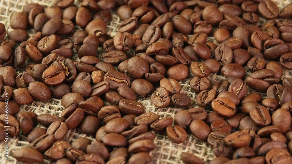Concept roasted coffee beans rotating on burlap in a coffee shop. An invigorating morning coffee for a productive workday or a warm evening