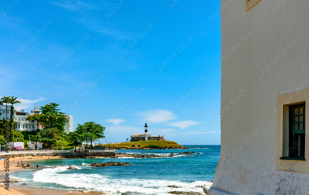 Obraz premium Porto da Barra beach in Salvador with the Barra Lighthouse and the city buildings in the background