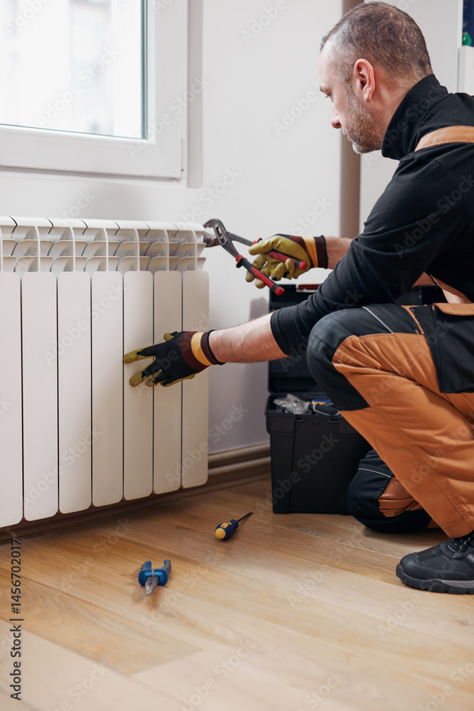 Central heating mechanic and handyman fixing home radiator, gas crisis and seasonal issues.