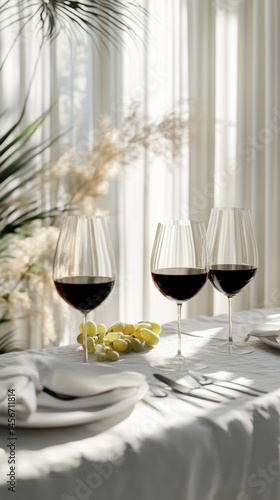 Obraz na płótnie Elegant wine glasses filled with red wine on a table with grapes in soft natural light closeup w salonie