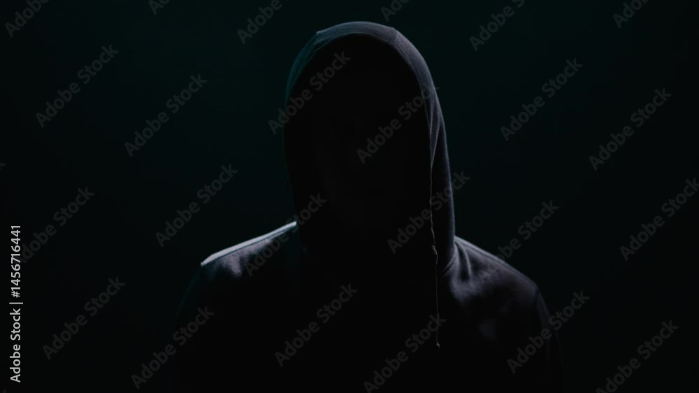 Enigmatic Figure Shrouded in Hooded Shadows