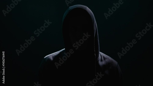 Enigmatic Figure Shrouded in Hooded Shadows