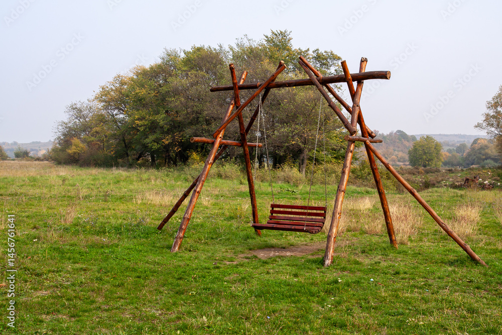 Rustic Handmade Wooden Log Swing Bench in Quiet Meadow: Peaceful Countryside Relaxation Scene and Childhood Memories Rustic Handmade Wooden Log Swing Bench in Quiet Meadow: Peaceful Countryside Relaxation Scene and Childhood Memories