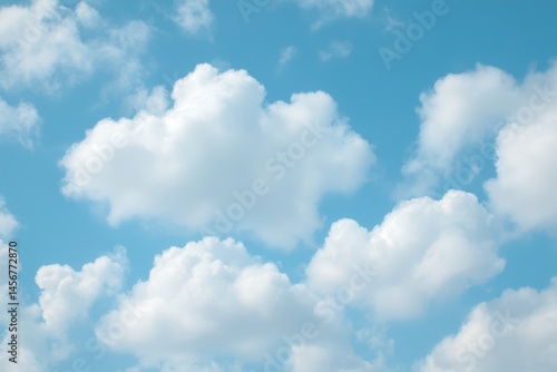 Obraz na płótnie Fluffy white clouds scattered across a bright blue sky on a clear, sunny day. w salonie
