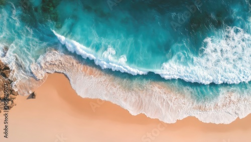 Obraz na płótnie Aerial view of turquoise waves crashing onto a sandy beach, creating a vibrant coastal scene with foamy surf and clear water. w salonie
