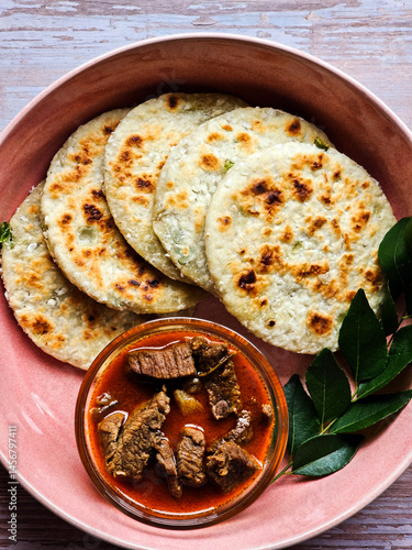 Sri Lankan breakfast meal coconut roti (Pol Roti) with beef curry garnished with carry leafs