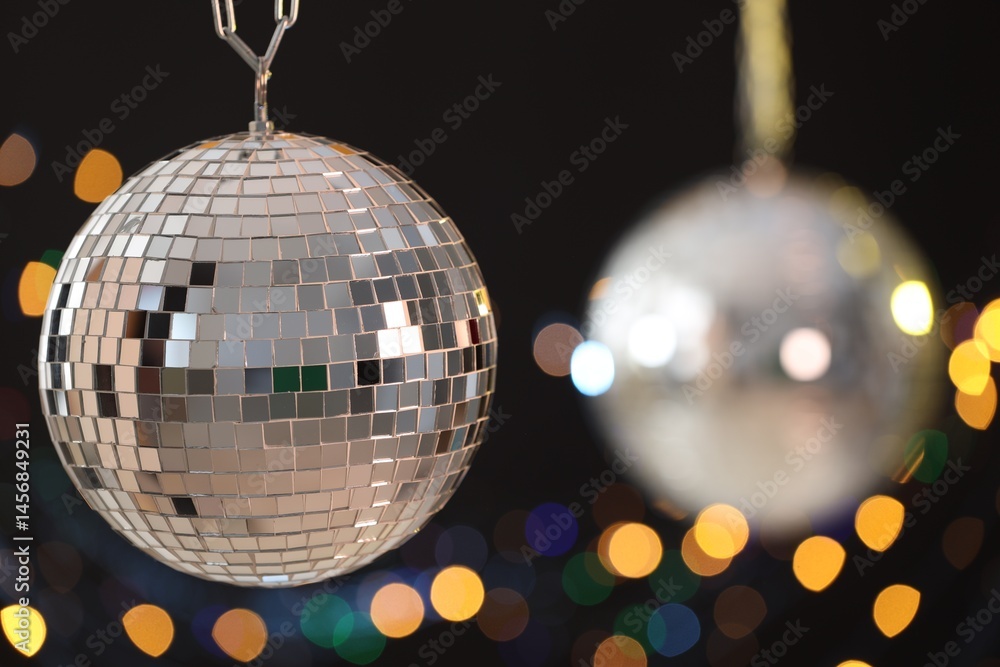 Fototapeta premium Shiny disco ball on black background with blurred lights