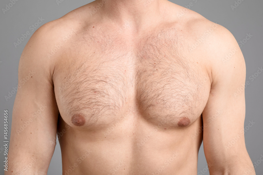 Fototapeta premium Young man with hairy chest on light grey background, closeup. Epilation procedure