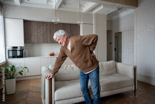 Photography Sad senior man hunches in agony after severe back spasm by lumbar disc herniation