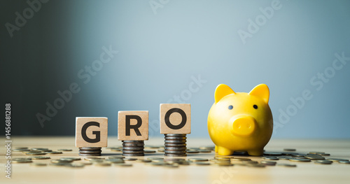 Obraz na plátne GRO abbreviation with wooden blocks on stacked coins, yellow piggy bank, and scattered coins, symbolizing financial growth, investment, wealth accumulation, and economic prosperity