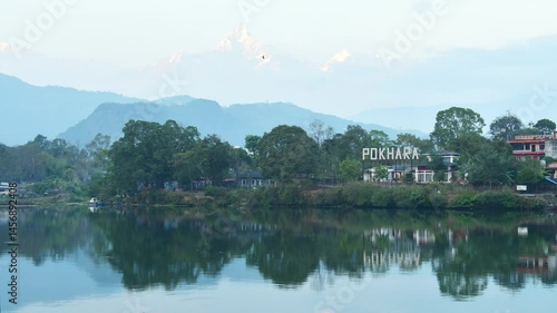 Annapurna mountain range reflection view on lake in Pokhara 4k zoom in timelapse. Pokhara city and Phewa Lake, central Nepal. Annapurna mountain range snowy peaks
