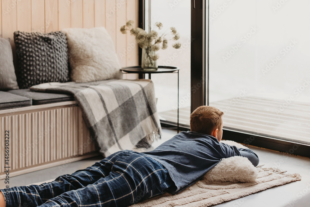 Teen Boy Lying on Floor Looking out Window