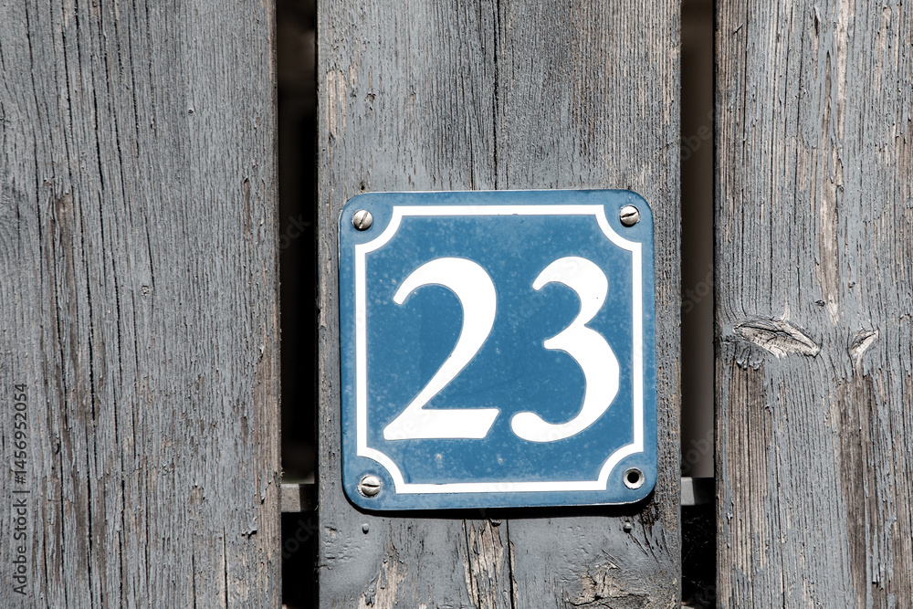 house numer t23 at a wooden wall