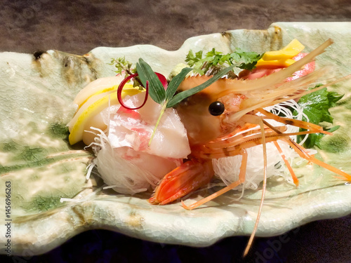 Large shrimp served in a fine plate with various raw garnishes