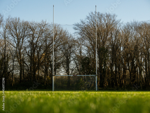 Obraz na płótnie Tall goalposts in a training field for rugby, camogie, hurling, Gaelic football which are National sports of Ireland. Nobody on the grass, Warm sunny day. w salonie