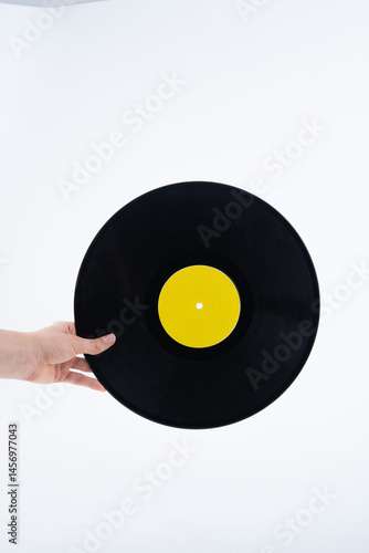 Hand Holding Black Vinyl Record with Yellow Label