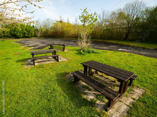 Picnic area with seats and tables in a forest park, warm sunny day. Nobody. Travel and tourism. The site is very clean and properly looked after.