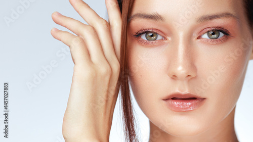 Obraz na płótnie Macro beauty shot of a Caucasian woman with radiant skin, nude glossy lips, and subtle peach-toned eye makeup - ideal for skincare, makeup brands, or high-end beauty product campaigns. w salonie